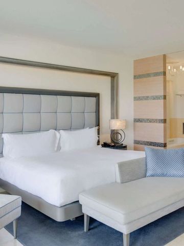 Modernes Schlafzimmer im Conrad Algarve mit bequemer Sitzgelegenheit und stilvollen Details.
