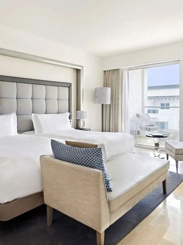 Modernes Hotelzimmer mit zwei Betten und großem Fenster mit Ausblick.