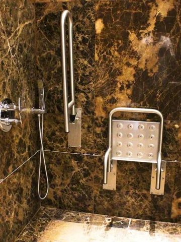 Luxuriöse Marmordusche mit Haltegriffen und klappbarem Sitz