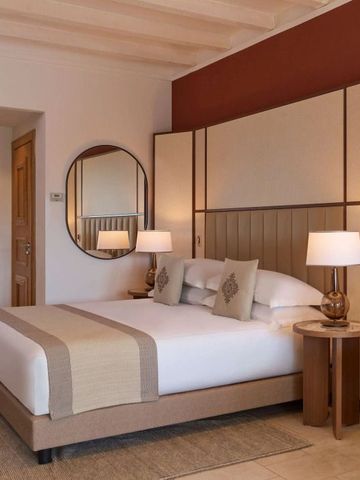 Modernes Hotelzimmer mit großem Bett und runden Spiegeln an der Wand.