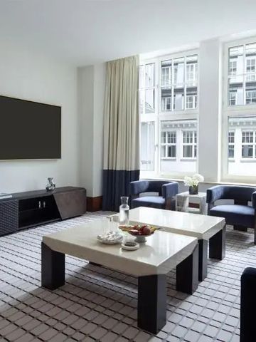 Moderner Wohnbereich mit großen Fenstern und stilvollen Möbeln