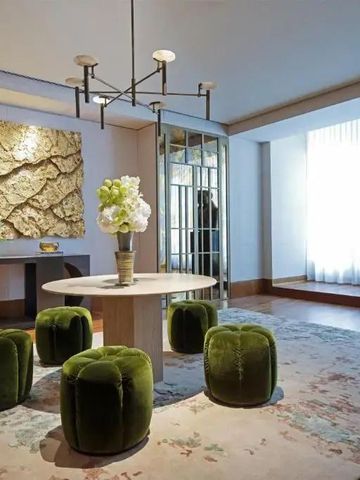 Elegante Lobby mit grünen Hockern und künstlerischer Wanddekoration