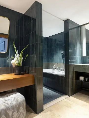 Luxuriöses Badezimmer mit moderner Einrichtung und dunklen Fliesen