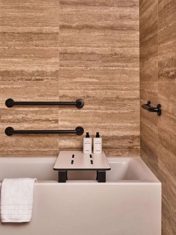 Modernes Badezimmer mit Badewanne und eleganten Oberflächen aus Naturstein