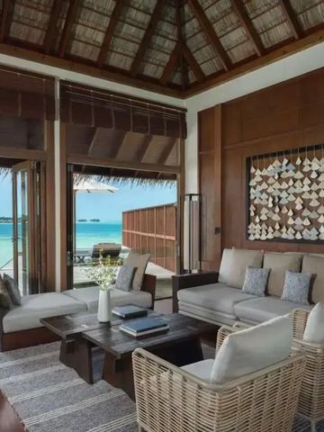 Gemütliche Lounge mit Rattansesseln und Blick auf das türkisfarbene Meer