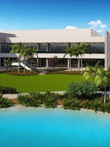 Moderner Hotelkomplex mit Pool und Palmen im Vordergrund