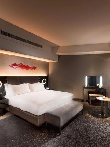 Elegantes Hotelzimmer im Conrad Osaka mit großem Bett und moderner Einrichtung