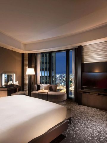 Zimmer im Conrad Osaka bei Nacht mit Beleuchtung und urbanem Ausblick