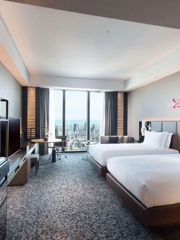Geräumiges Hotelzimmer mit zwei Betten und Blick auf Osaka