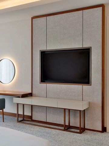 Modernes Hoteldesign mit großem Flachbildfernseher und bequemer Sitzgelegenheit.