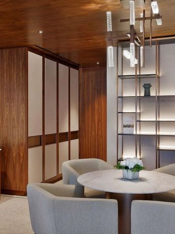 Stilvolle Sitzecke mit Rundtisch und moderner Beleuchtung in warmen Holztönen.