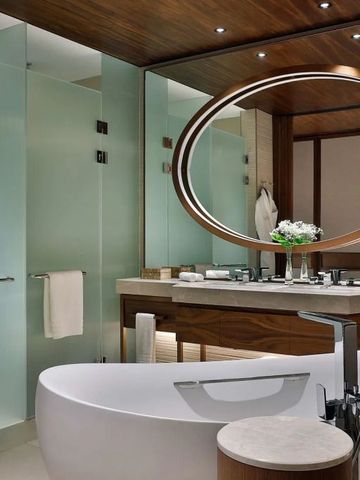 Luxuriöses Badezimmer mit freistehender Badewanne und stilvollem Holzdesign.