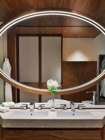 Luxuriöses Badezimmer mit großem, ovalem Spiegel und Doppelwaschbecken