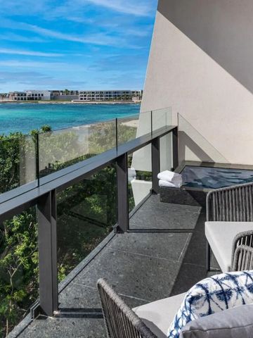 Balkon mit Sitzbereich und Blick auf türkisfarbenes Meer und blauen Himmel
