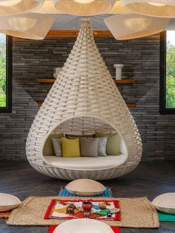 Moderne Lounge mit beeindruckendem geflochtenem Sitzmöbel und heller Dekoration