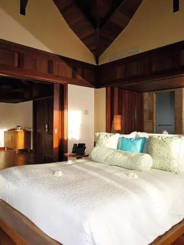 Geräumige Suite mit Holzakzenten, luxuriösem Bett und gemütlichem Ambiente