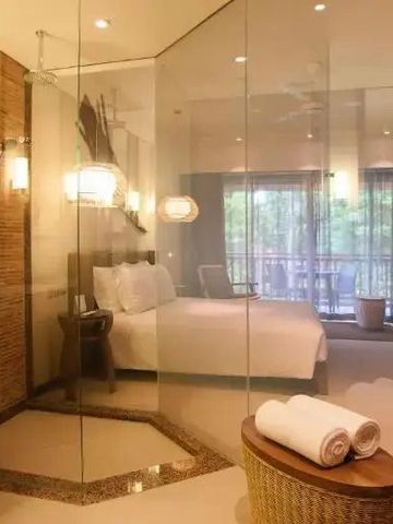 Modernes Hotelzimmer mit Glaswänden und Blick auf den Balkon