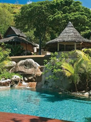 Tropischer Poolbereich mit Palmen und traditionellen Hütten im Hotel Constance Lemuria.