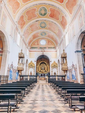 Prächtige Kirche mit verzierter Decke und Altar im Hintergrund