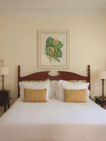 Elegantes Schlafzimmer mit Kunstwerken an der Wand und Nachttischen.