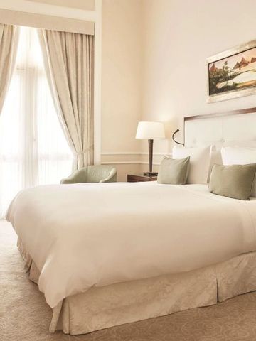 Luxuriöses Schlafzimmer mit großem Bett und eleganten Vorhängen.