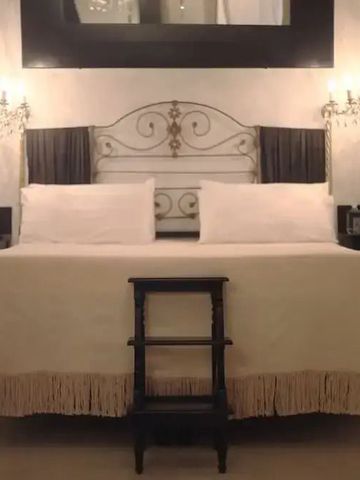 Helles Schlafzimmer mit großem Doppelbett und Kronleuchtern