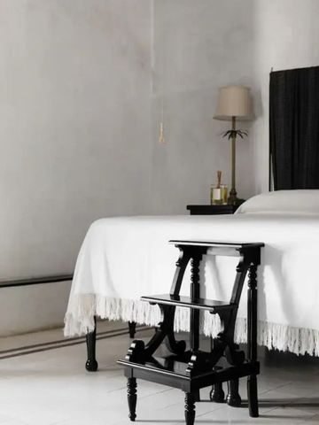 Helles Schlafzimmer mit weißer Bettwäsche und stilvoller Stehlampe