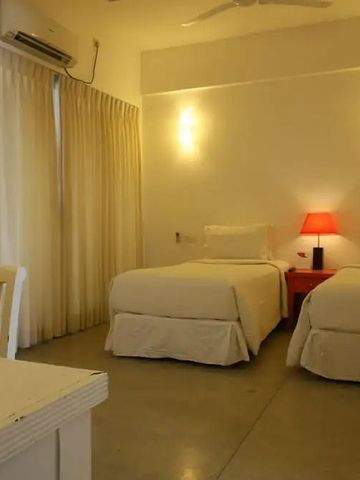 Modernes Hotelzimmer mit zwei Einzelbetten und roter Lampe