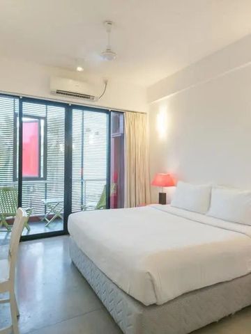 Helles Hotelzimmer mit Doppelbett und Schreibtisch