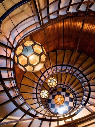 Elegantes Wendeltreppen-Design mit kunstvollen Lichtern im Cotton House Hotel