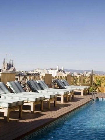 Außenpool mit Liegestühlen und Blick auf die Stadt im Cotton House Hotel
