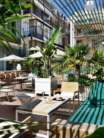 Üppig gestaltete Hotelterrasse mit Palmen und gemütlichen Sitzgelegenheiten