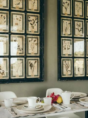 Dekorativer Essbereich mit botanischen Drucken an der Wand