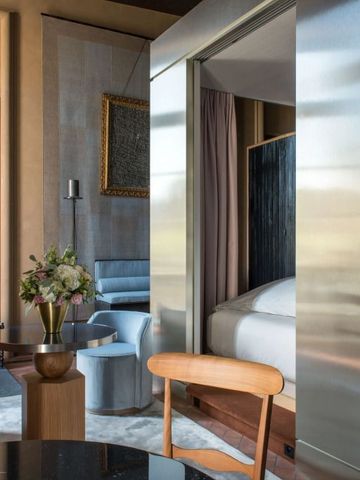 Elegante Hotelsuite mit moderner Einrichtung und Blumenarrangement.