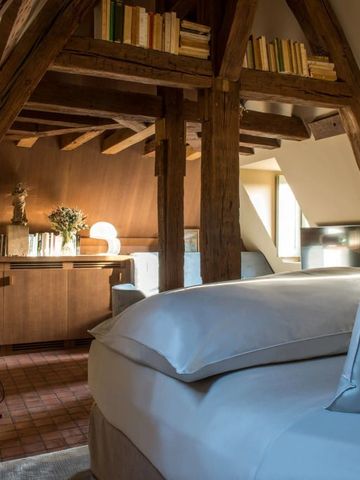 Gemütliche Suite im Dachgeschoss mit Holzbalken und Bücherregal