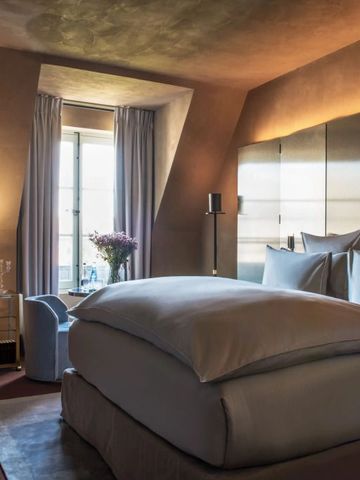 Elegantes Schlafzimmer mit stilvoller Beleuchtung und großen Fenstern