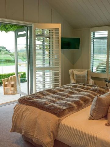 Luxuriöses Schlafzimmer mit großem Bett und Blick auf Terrasse und Garten.