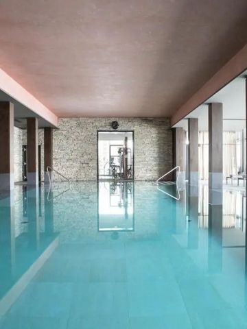 Hallenbad mit ruhigem, kristallklarem Wasser und moderner Architektur