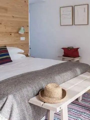 Kuscheliges Schlafzimmer mit Holzdetails, gemütlichem Bett und rustikalem Detail.