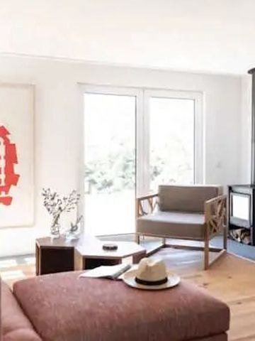 Einladendes Wohnzimmer mit moderner Kunst, Kamin und großen Fenstern.