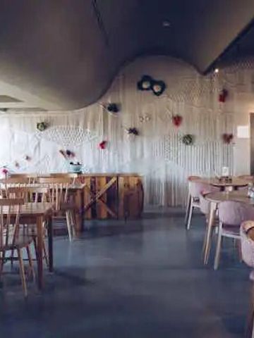 Elegantes Restaurantinterieur mit modernen Holzstühlen und künstlerischer Dekoration