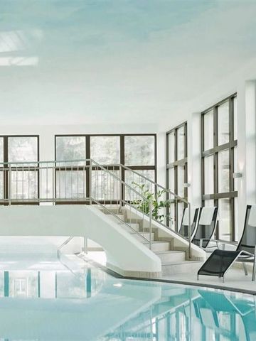 Eleganter Innenpool mit großen Fenstern und Liegestühlen