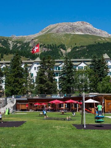 Großer Garten mit Spielplatz und Bergblick im Sommer.