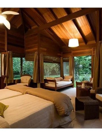 Großzügiges Zimmer mit Holzdekor und Blick ins Grüne.