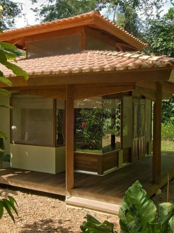 Holzpavillon mit Pflanzen umgeben in tropischer Umgebung