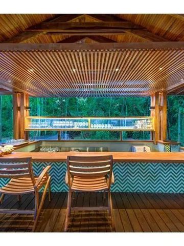 Barbereich mit stilvollen Holzstühlen und moderner Beleuchtung im Freien