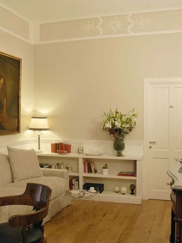 Eleganter Wohnraum mit antiken Möbeln und klassischem Gemälde