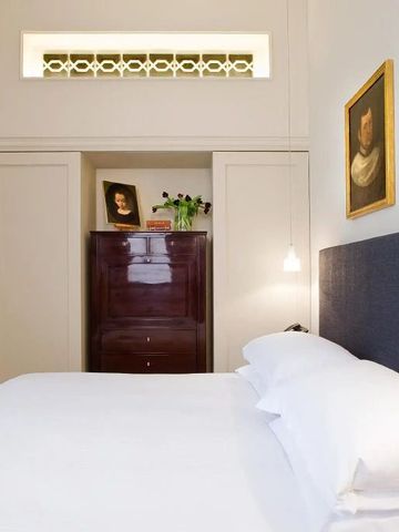 Elegantes Gästezimmer mit schlichter Dekoration und Kunstwerken an der Wand