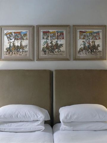 Komfortables Doppelzimmer mit gepolstertem Kopfteil und stilvollen Wandgemälden