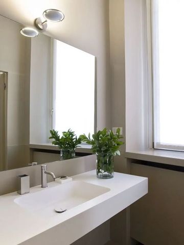 Helles Badezimmer mit großem Spiegel und eleganten Waschbecken